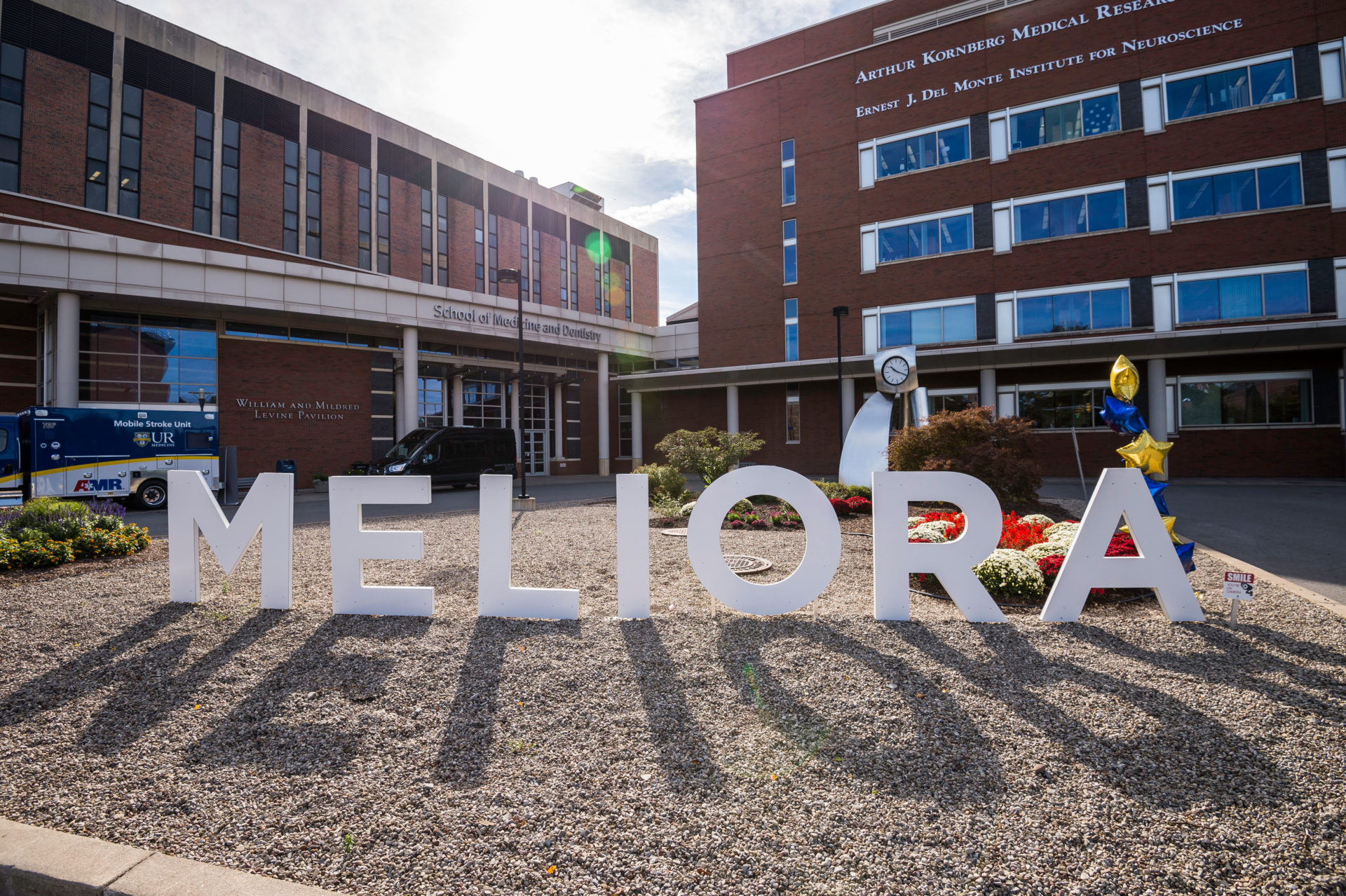Large letters spelling out "MELIORA" on the lawn outside the University of Rochester Medical Center